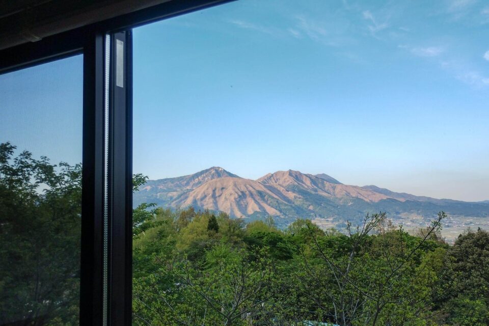 共有キッチンやダイニングテーブルがあるスペースからはカッコいい阿蘇山が見えました。